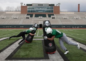 Photo of two footlball players tackling the robots
